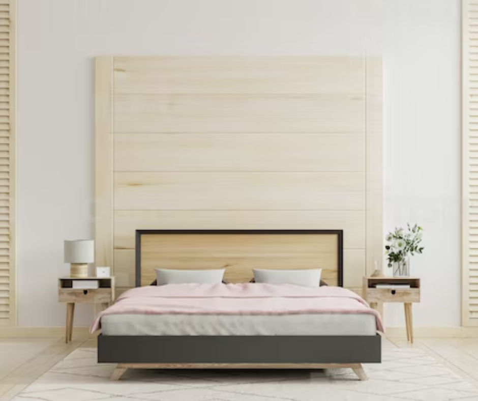 Picture of a bed with a solid light wood paneled wall behind the head of the bed.